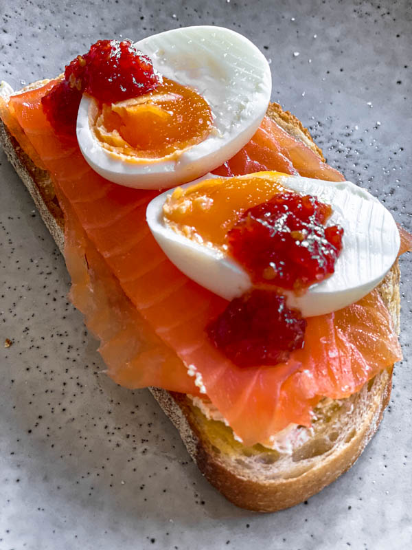 A piece of toast with smoked salmon and boiled eggs that have had some Tomato Chilli Jam dolloped on top. Delicious!