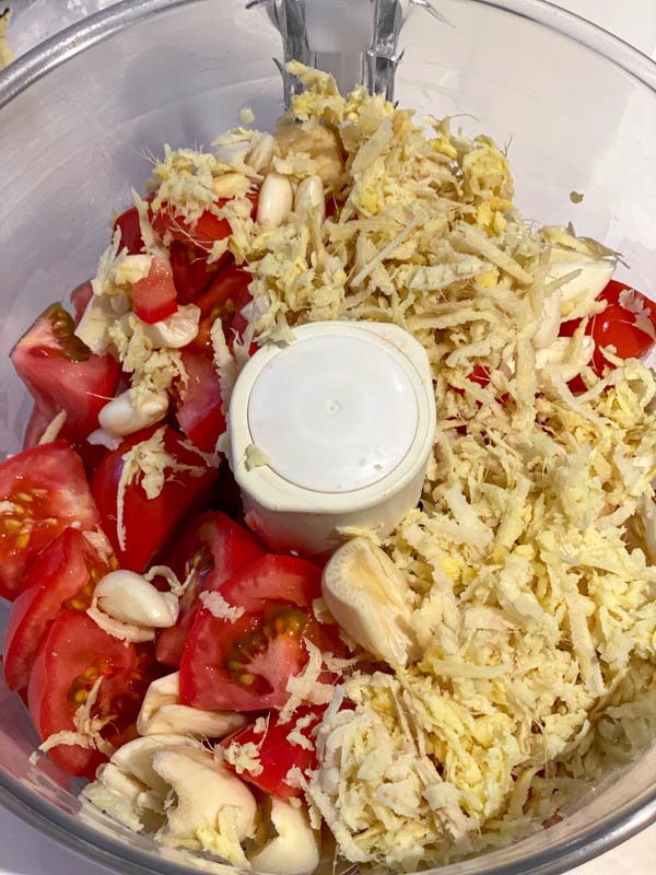 The ingredients in the bowl of a food processor ready to be blended together.