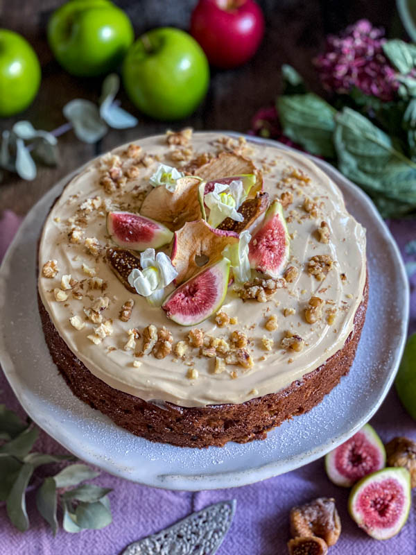 A side on view of the decorated Apple Fig and Walnut Cake with Maple Cream Cheese Frosting.