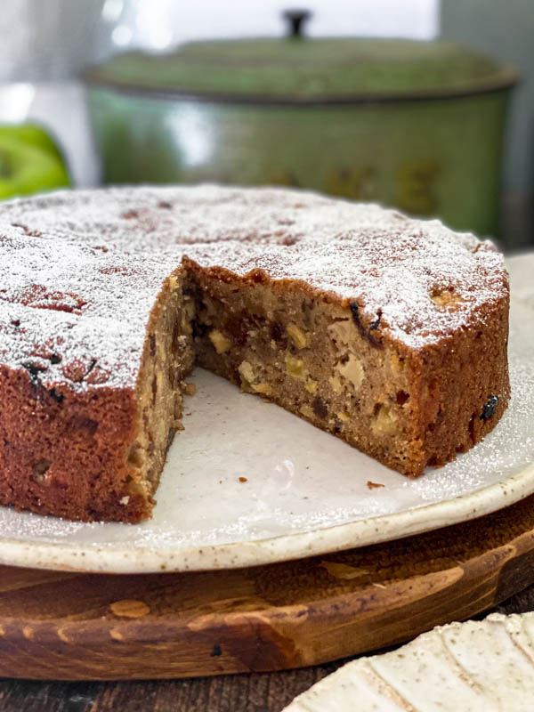 A close up of the inside of the spiced apple cake showing how moist the crumb is and how it is filled with apple and sultanas.