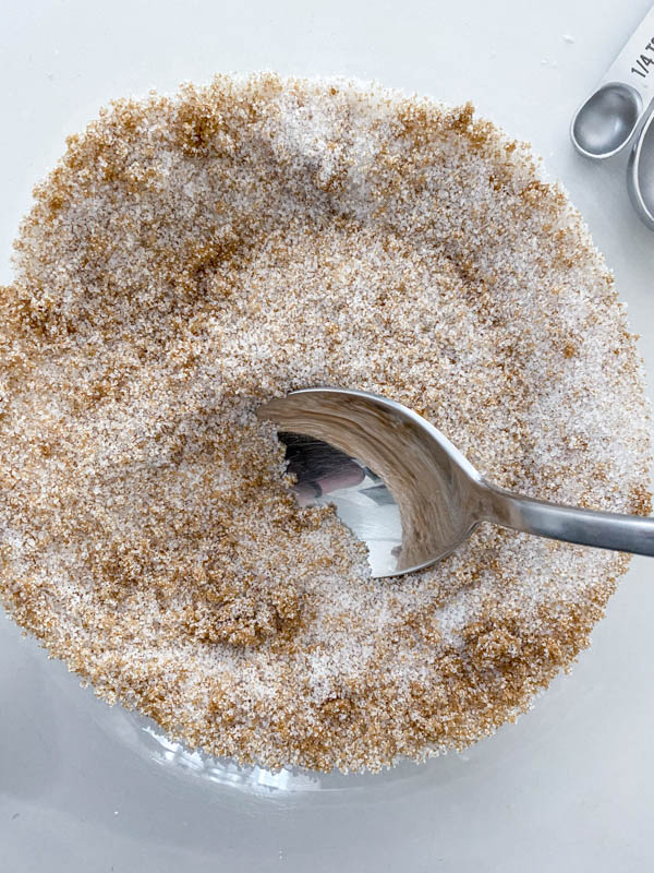 The white sugar and brown sugar are mixed together and in a glass bowl.