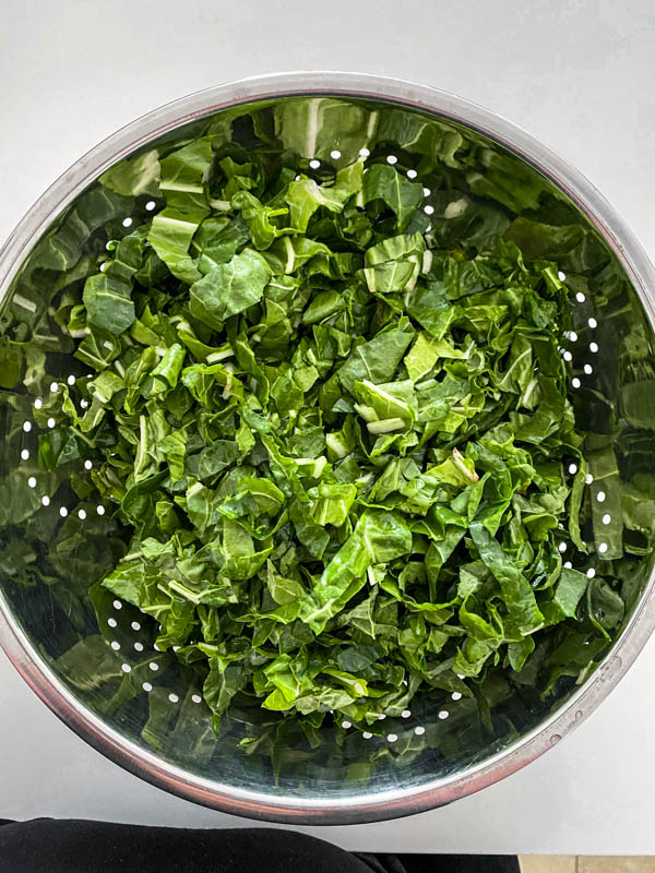 The chopped silverbeet is in a colander after being rinsed.