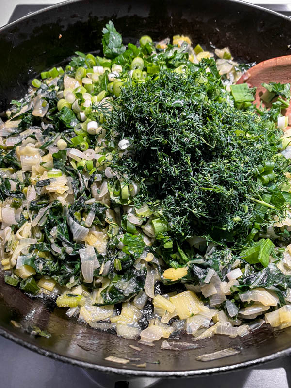 The herbs and spring onions are now added to the silverbeet mixture in the frying pan off the heat.