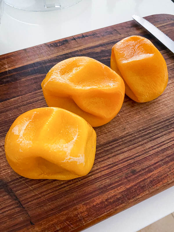 The boiled Meyer lemons are on a chopping board cooling down.