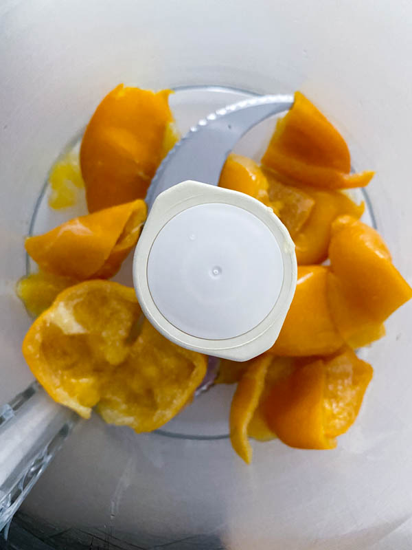 Looking down into the food processor bowl where the Meyer lemon pieces are ready to be blended.