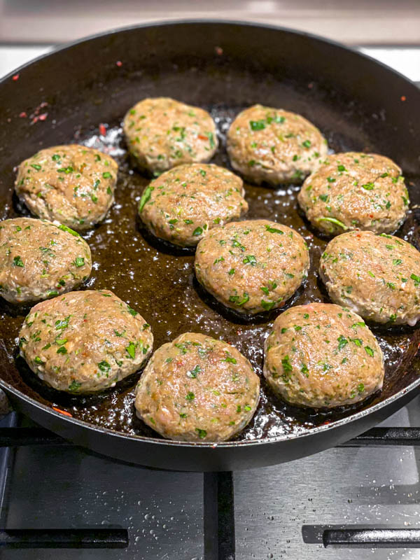 The Kofta patties are frying off in a pan.