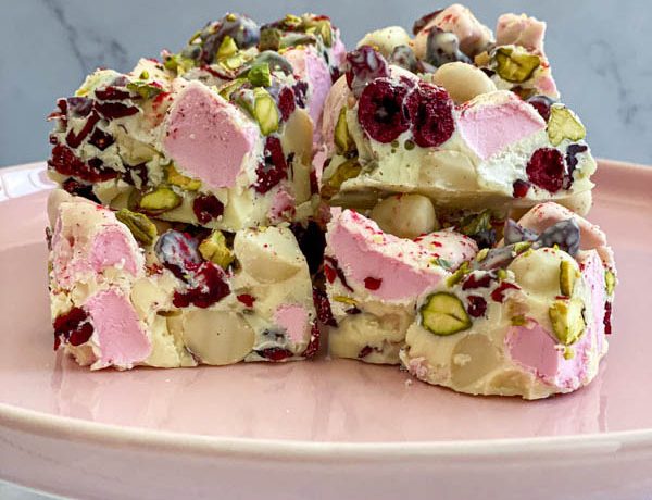 A close up of the rocky road pieces on a pink cake stand.