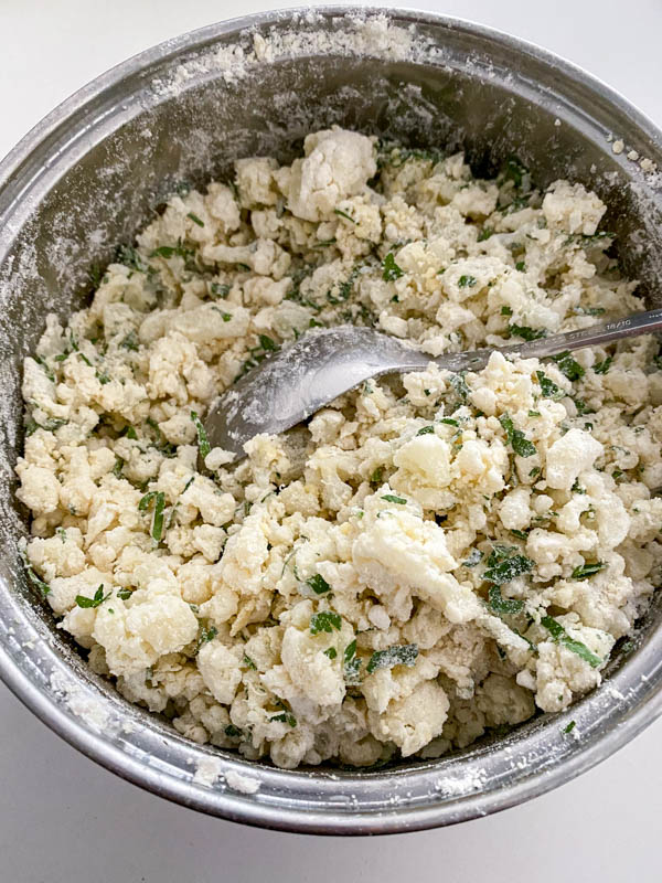 The flour, cheese and parsley are now mixed through the cauliflower. This is done carefully, so as not to break up the cauliflower too much.