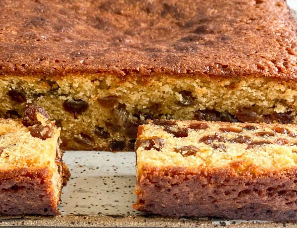 A close-up of the cut cake showing the moist interior that is studded with sultanas.