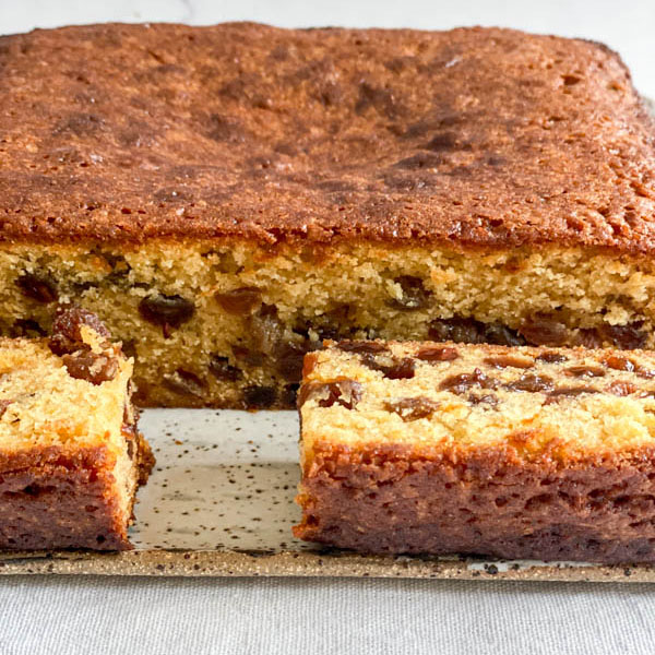 A close-up of the cut cake showing the moist interior that is studded with sultanas.