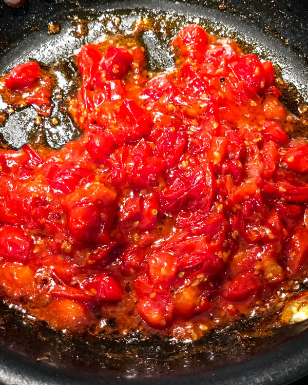A close up of the breakfast tomatoes in the frying pan. They have reduced and are ready for serving.