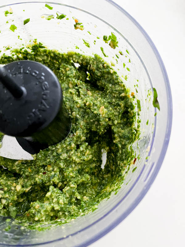 The ingredients are now all blended and made into a pesto. It is pictured here in the bowl of the mini food processor.