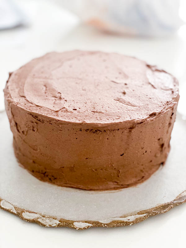 This shows the 2 layer chocolate cake now fully covered in Chocolate Buttercream frosting.