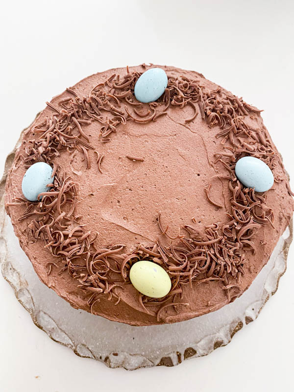 Mini Easter eggs are now being placed around the outside of the top of the cake on top of the grated chocolate.