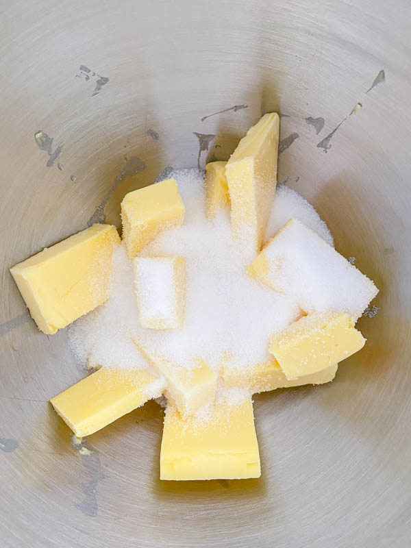 The softened butter and sugar are in the bowl of a stand mixer.