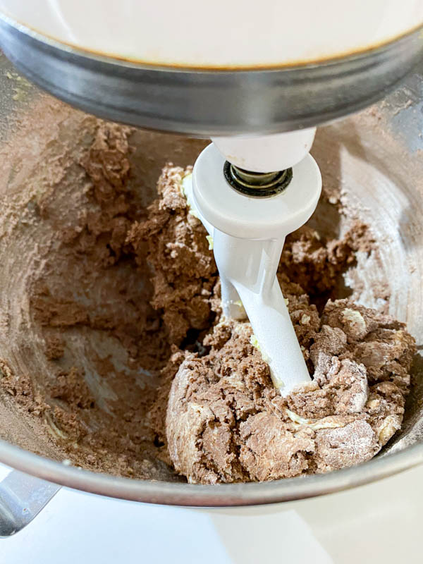 Both the creamed butter and dry ingredients are now being beaten together in the bowl of a stand mixer.