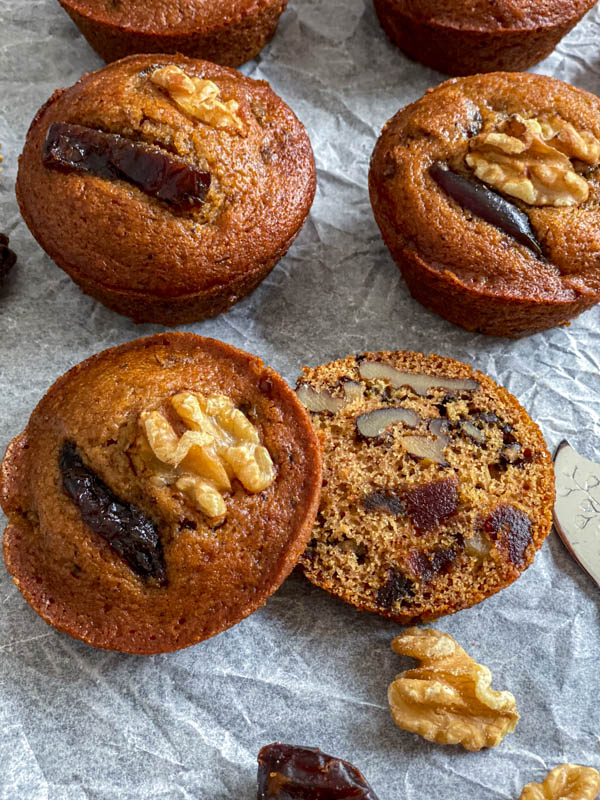 A close up looking down on the sliced muffin. It is full of dates and walnuts and the texture of the muffin is very moist.