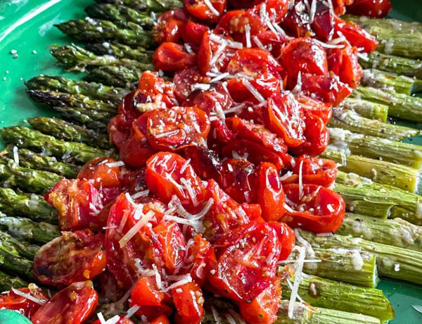 The salad is ready to be served on a round green platter.